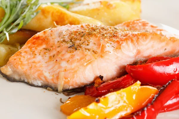 Филе лосося на гриле с овощами, специями и рукколой на тарелке — стоковое фото