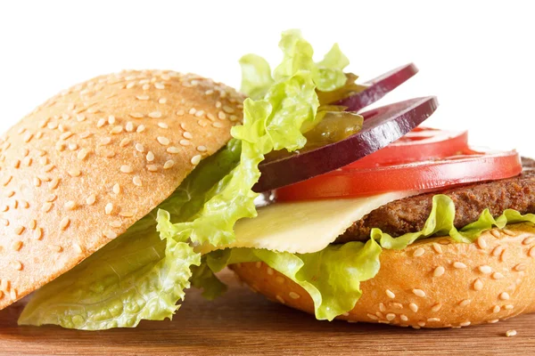 Hamburguesa tradicional americana con queso. Carne, bollo y verduras de cerca —  Fotos de Stock