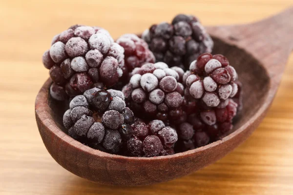 Vista macro em frutas congeladas de amora na colher — Fotografia de Stock