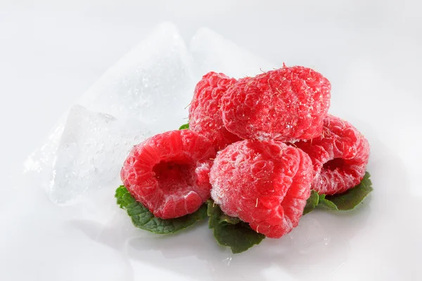 Frambuesas congeladas con hojas de menta sobre blanco — Foto de Stock