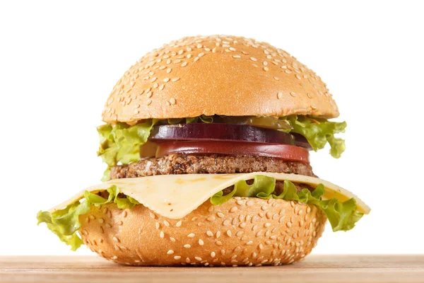 Traditional American cheeseburger. Meat, bun and vegetables close up