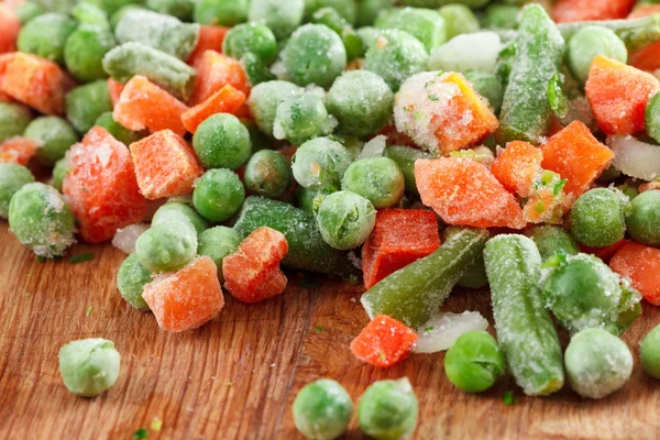 Produtos hortícolas congelados sobre tábua de corte — Fotografia de Stock