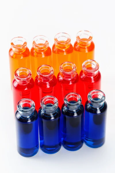 Blue, red and orange liquid in chemical lab test tubes on white background — Stock Photo, Image