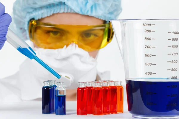 Студент з піпеткою, захисний одяг, окуляри в хімічній лабораторії — стокове фото