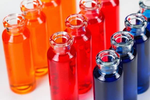 Blue, red and orange liquid in chemical lab test tubes on white background — Stock Photo, Image
