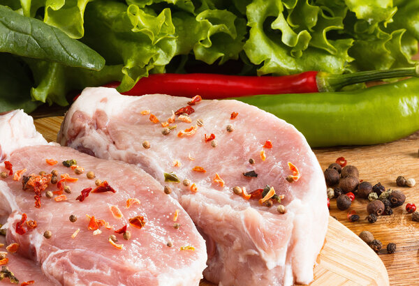 Raw steak with vegetables, spices and herbs