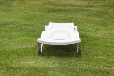 Güneş-güneşli bir çim sandalyede