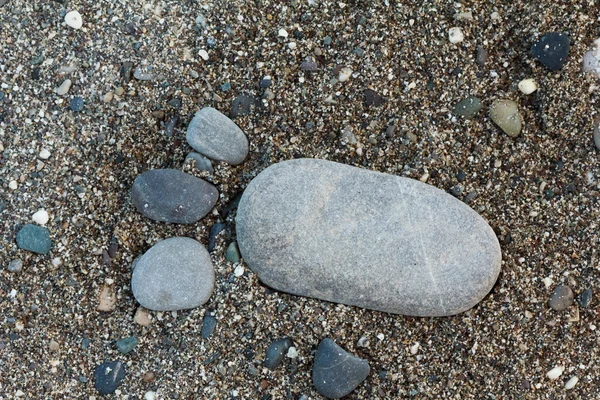 Fußgruppe mit Kieselsteinen auf Sandgrund — Stockfoto