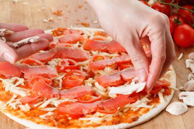Somon balığı, domates ve mantar ile ev yapımı pizza pişirme