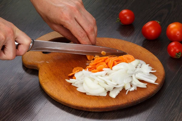 Taglio di carota e cipolle su un'asse — Foto Stock