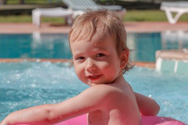 Küçük çocuk havuzda oynuyor.