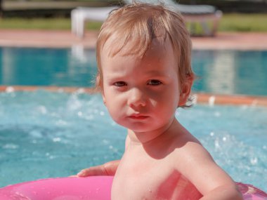 Küçük çocuk havuzda oynuyor.