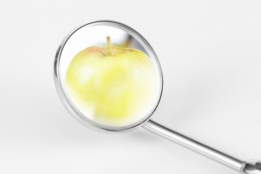 Green apple and dental tools on white clipart