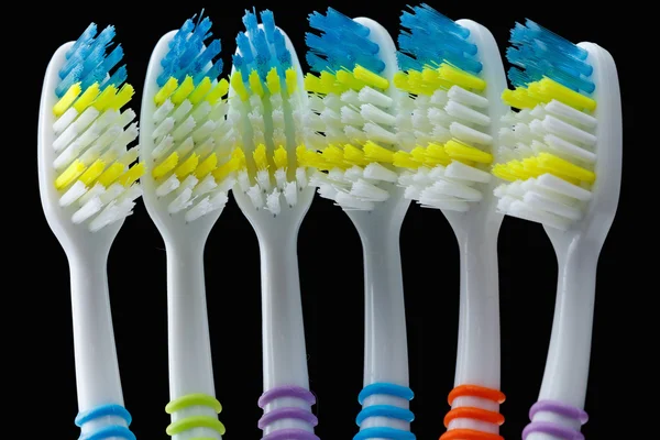 Set of colorful toothbrushes over black — Stock Photo, Image