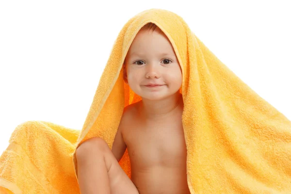 Happy baby wearing yellow towel sitting after bath or shower. — Stock Photo, Image