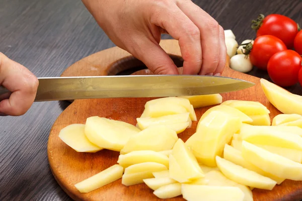 Skär potatis på ett bräde — Stockfoto