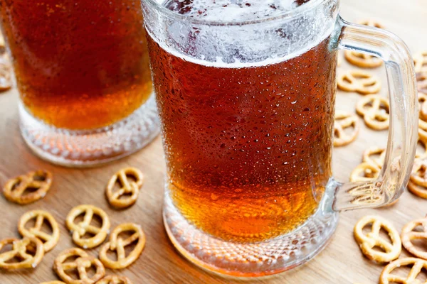 Mug of cold foamy beer with german brezel