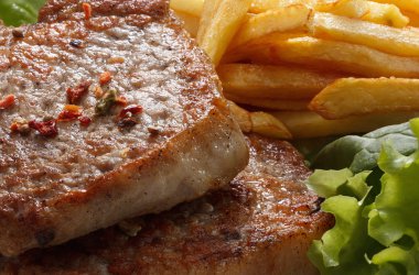 Sulu kavrulmuş domuz biftek ile kızarmış patates ve baharatlar