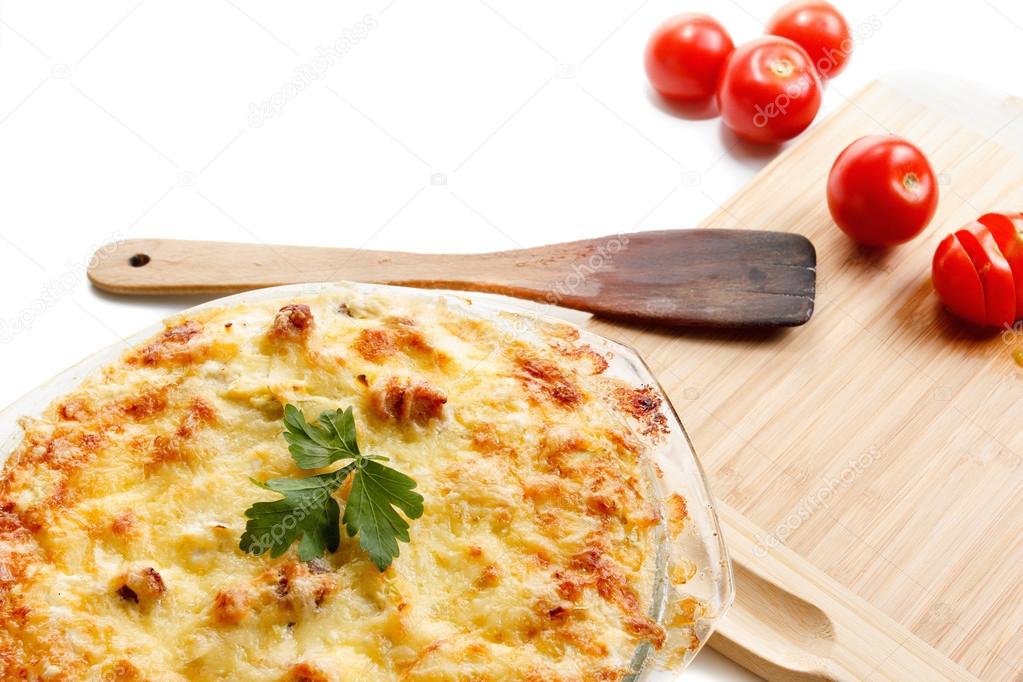 Squash and meat, fried with cheese, tomato, cottage cheese in a glass. Casserole, cooking, kitchen