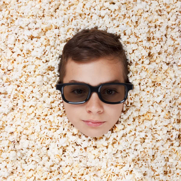 Ernster kleiner Junge in Stereogläsern schaut aus Popcorn — Stockfoto