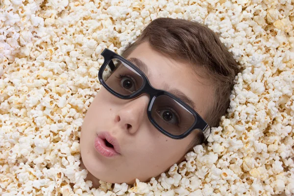Überraschungsjunge in Stereobrille schaut aus Popcorn — Stockfoto