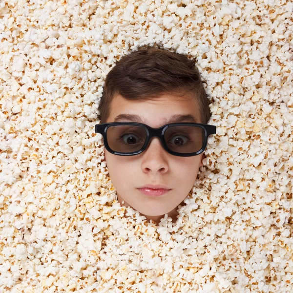 Überraschungsjunge in Stereobrille schaut aus Popcorn — Stockfoto