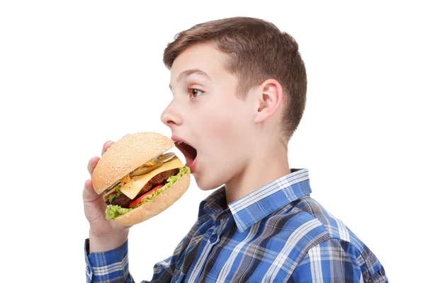 Мальчик держит бургер и открывает рот, чтобы поесть. — стоковое фото