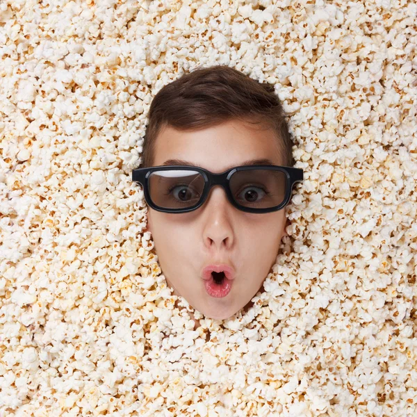 Überraschungsjunge in Stereobrille schaut aus Popcorn — Stockfoto