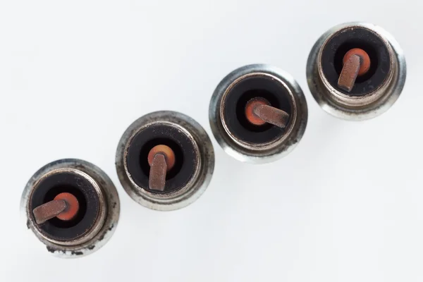 Close-up four old burned spark plugs — Stock Photo, Image