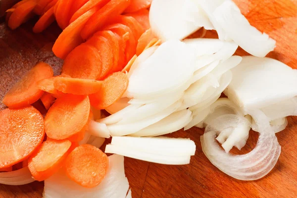 Pokroić cebulę i marchew na desce do krojenia — Zdjęcie stockowe