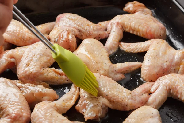 Raw chicken wings on a baking sheet