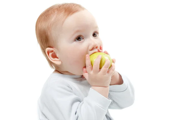 Baby isst grünen Apfel. Studioporträt in halber Länge, isoliert auf weißem Hintergrund — Stockfoto