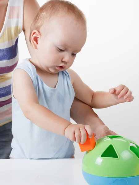 Mama bringt dem Baby bei, Spielzeug zu legen. Studiodreh — Stockfoto