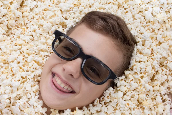 Lachender kleiner Junge in Stereogläsern, der aus Popcorn schaut — Stockfoto