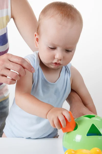 Mama bringt dem Baby bei, Spielzeug zu legen. Studiodreh — Stockfoto