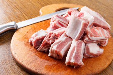 Raw pork ribs and knife on a cutting board clipart