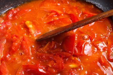 Demet taze kırmızı domates bir tavada pişirilmiş dilimlenmiş