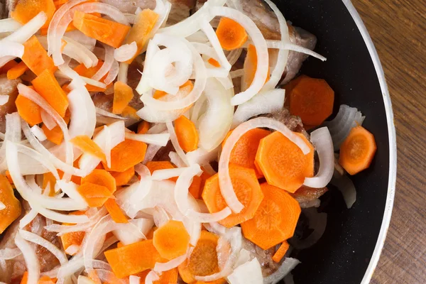 Gebratene Schweinerippchen mit Karotten und Zwiebeln in der Pfanne — Stockfoto