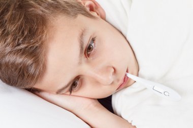 genç bir termometre ile yatakta. Grip veya soğuk sıcaklık.