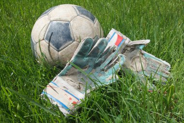 Futbol topu ve kaleci eldiven çimenlerin üzerinde