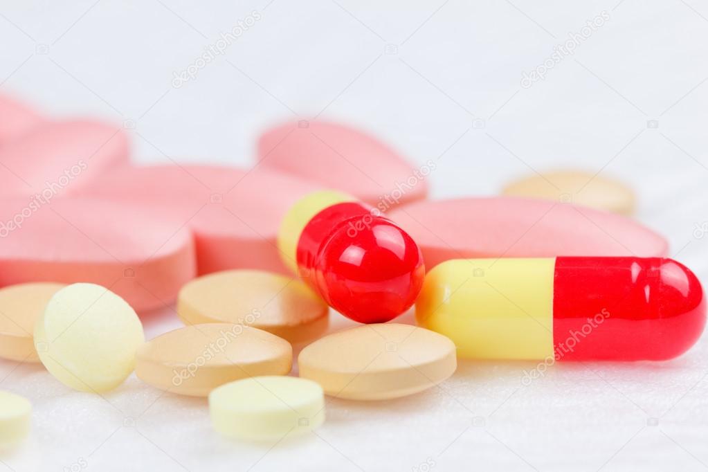 Multicolored Tablets of medicine on white background.