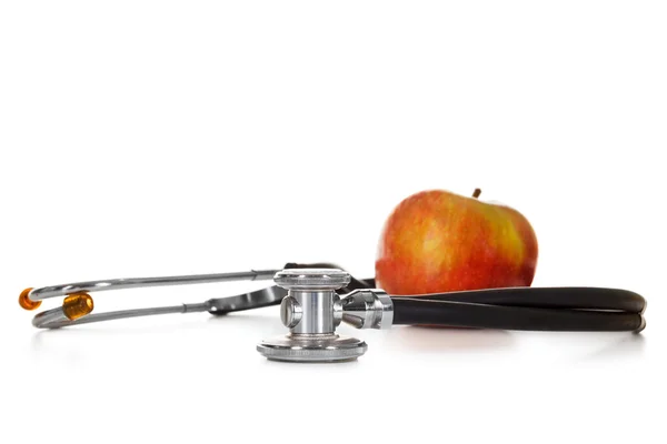 Manzana roja y estetoscopio sobre fondo blanco — Foto de Stock