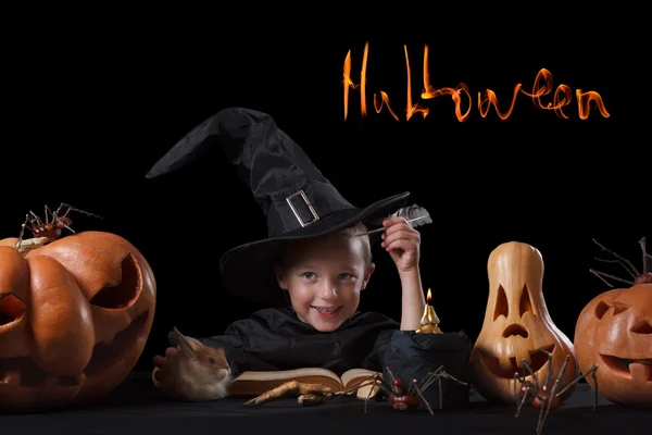 Child, Halloween pumpkin and magical things  on black background — Stock Photo, Image