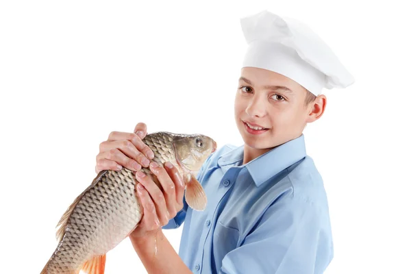 Young chef holding a fish carp on white background — Stock Photo, Image