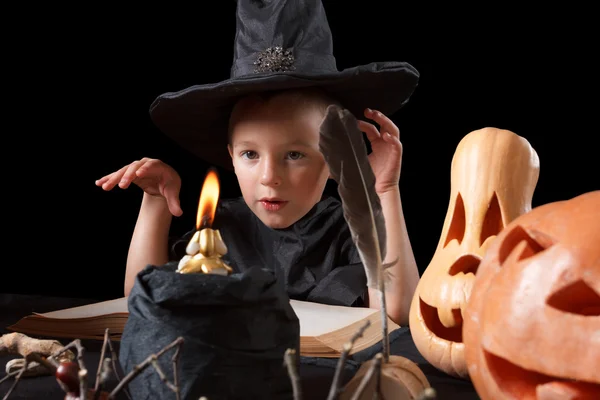 Halloween. Niño, calabaza y cosas mágicas sobre fondo negro — Foto de Stock