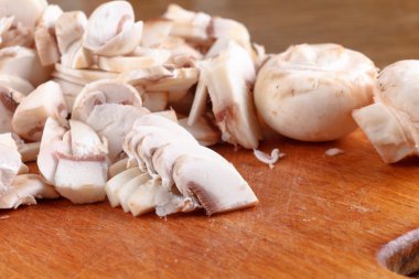 Ahşap tahta üzerinde champignon mantar dilimlenmiş