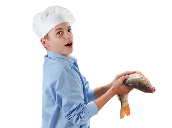 Young chef holding a fish carp on white background — Stock Photo, Image
