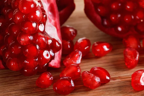 Ripe pomegranate seeds close-up on a cutting wooden board — Stock Photo, Image