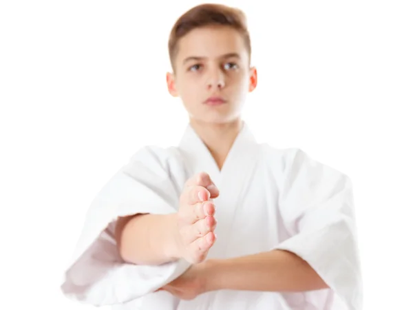 Martial art sport karate - kind tiener jongen in witte kimono opleiding punch en blok — Stockfoto