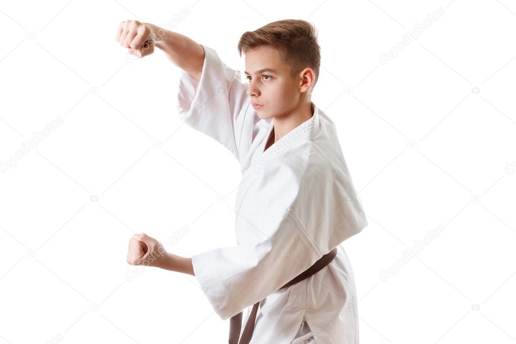 Martial art sport karate - child teen boy in white kimono training punch and block